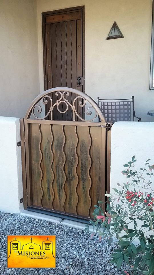 rust with black coloring, small single door, solid with wavy lines, steel metal courtyard gate