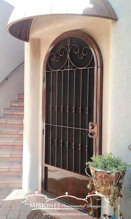 single arched security screen door with decorative scrolls and vertical bars with knuckle detailing, in a glossy rust finish