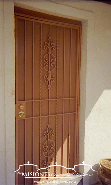 security screen door with vertical bars and two simple floral embellishments at the top and bottom of the door, tan finish