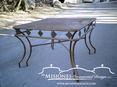 brown outdoor metal table, mesh top, diamond pattern detailing sides, legs are curved